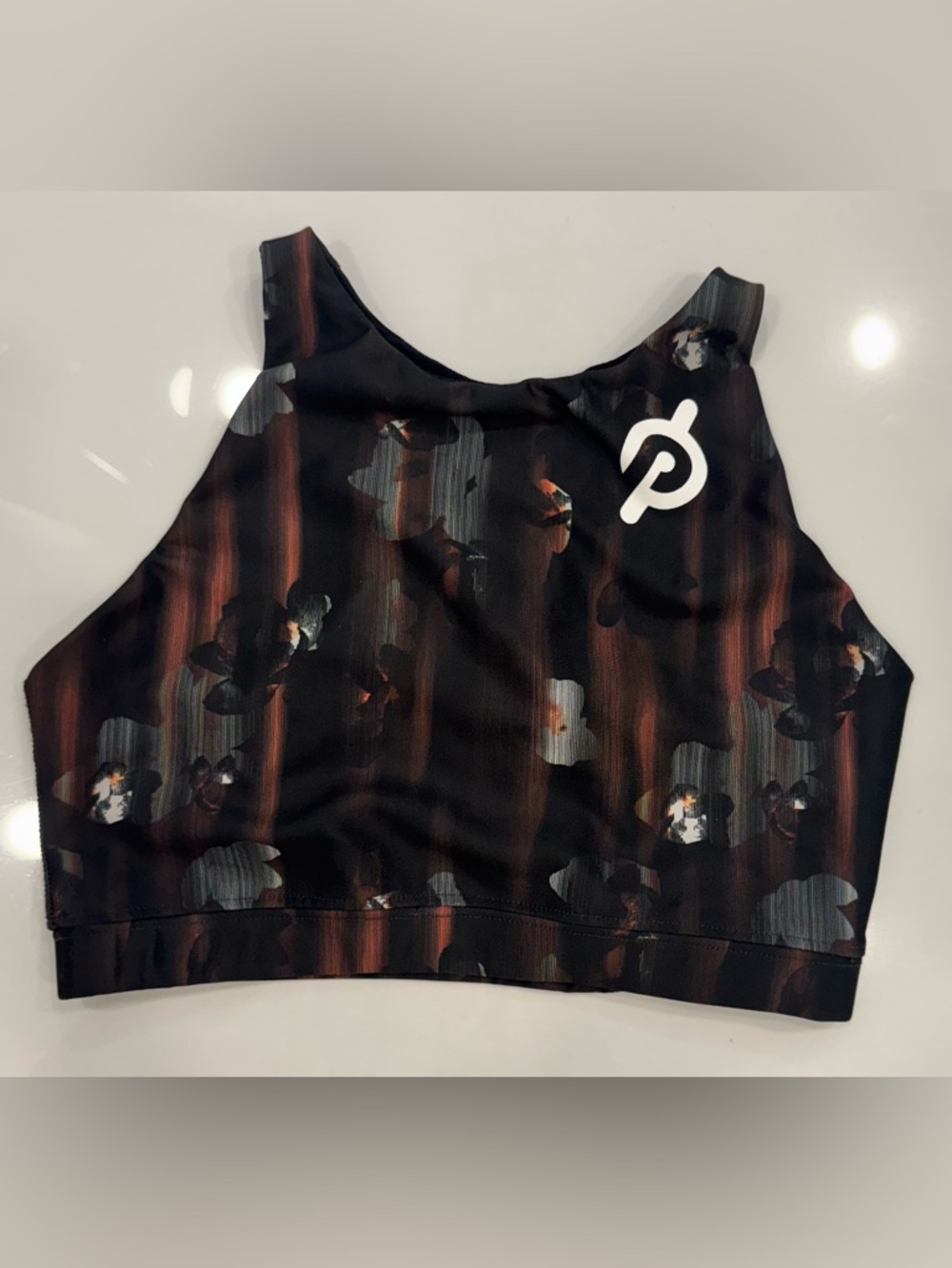 Peloton Racer Back Sports Bra Top with Black, Rust and Gray Floral Accents.